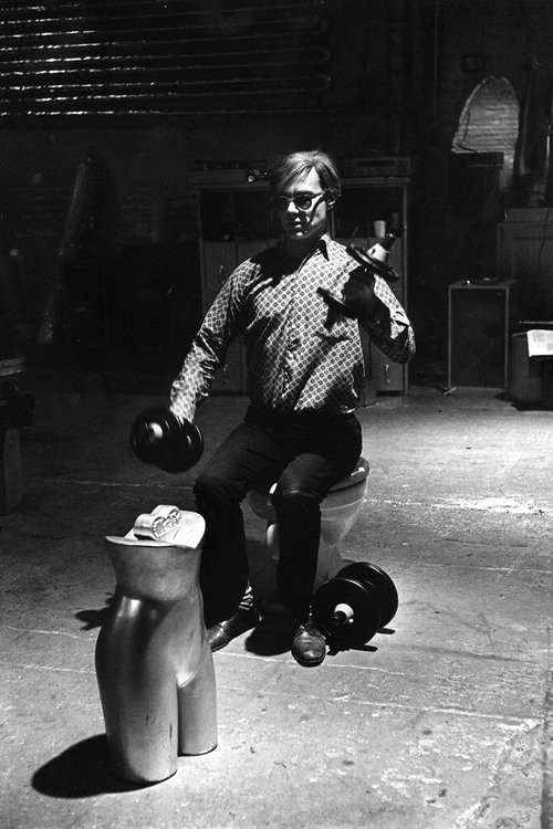 Eve Arnold, Andy Warhol, exercising seated on the toilet, in the Silver Factory, New York. Eve Arnold, Andy Warhol, exercising seated on the toilet, in the Silver Factory, New York.