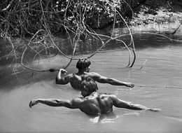 Fotografien, Two Kuikuro men pull the fishing net through the lake near their village in preparation for the women’s ceremony during Kuarup. Xingu Indigenous Territory, State of Mato Grosso, Brazil (XL), Sebastião Salgado